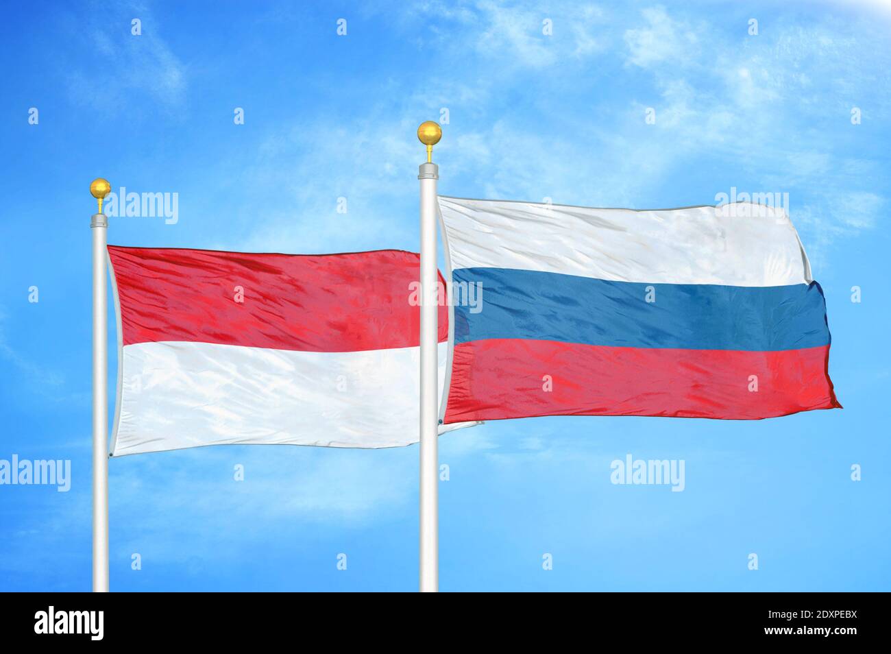 Indonésie et Russie deux drapeaux sur les mâts et bleu nuageux ciel Banque D'Images
