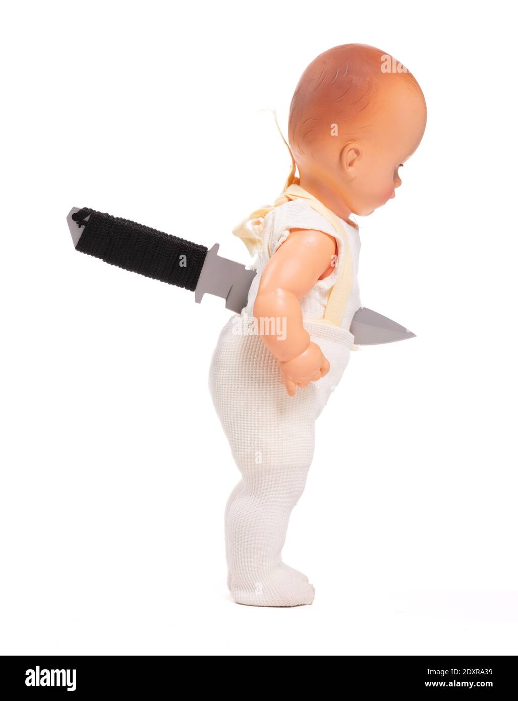 Vieille poupée cassée, couteau dans le dos, isolé sur fond blanc Banque D'Images