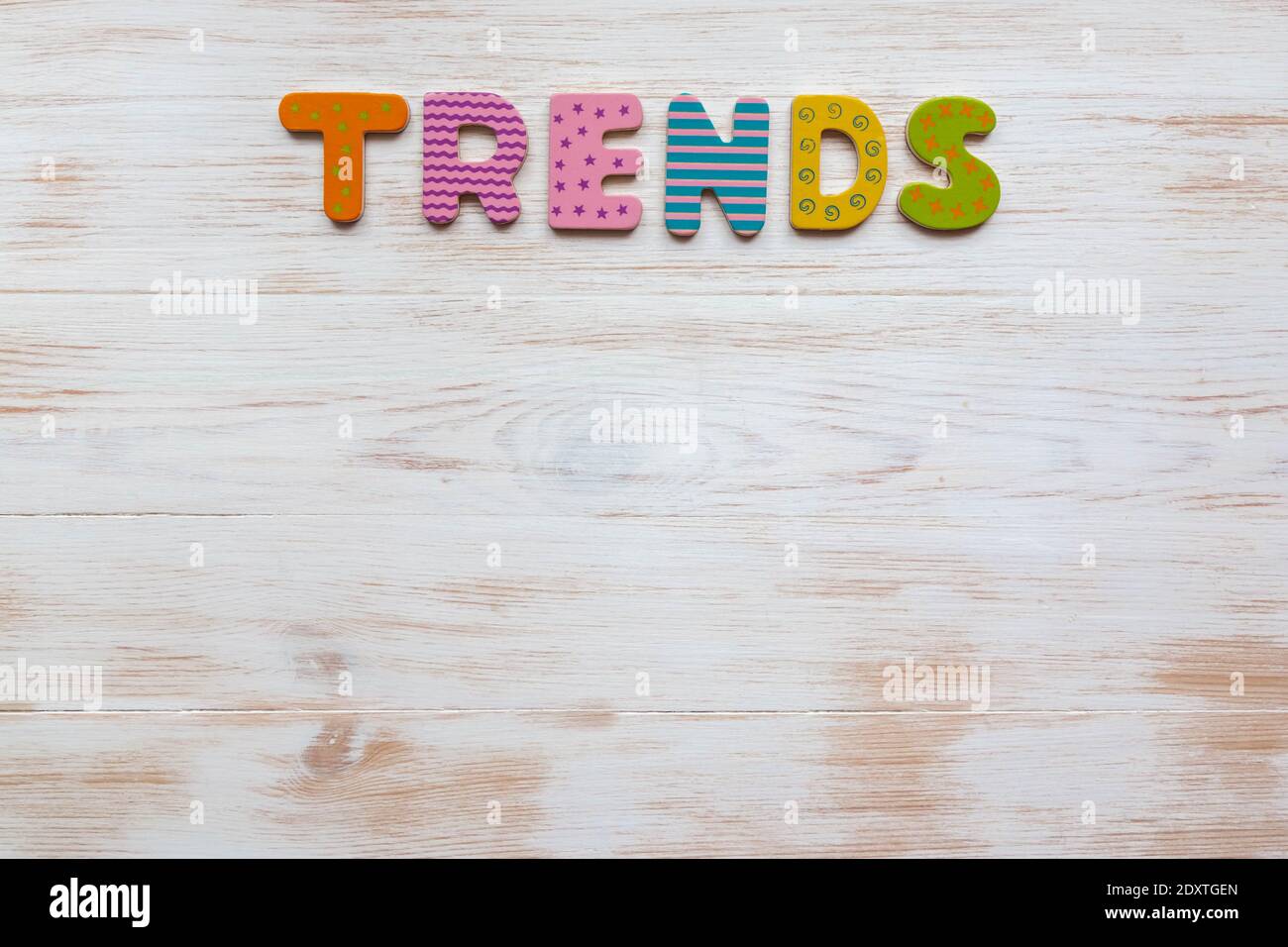 Tendances de mot sur bois. Lettres multicolores, message texte pour carte, bannière avec inscription. Des tendances de mot coloré sur blanc peint en bois d'époque ba Banque D'Images