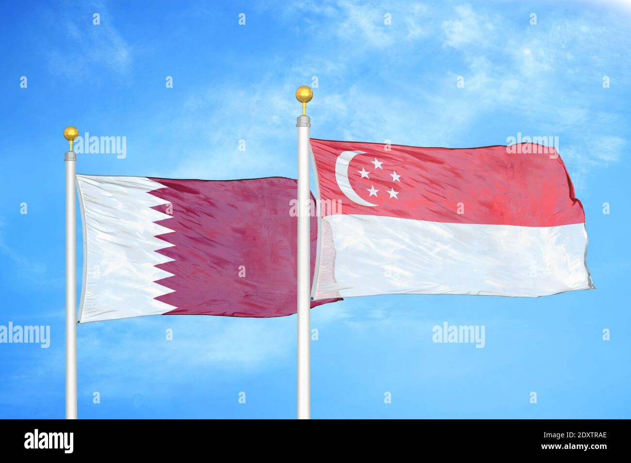 Qatar et Singapour deux drapeaux sur les mâts et bleu nuageux ciel Banque D'Images