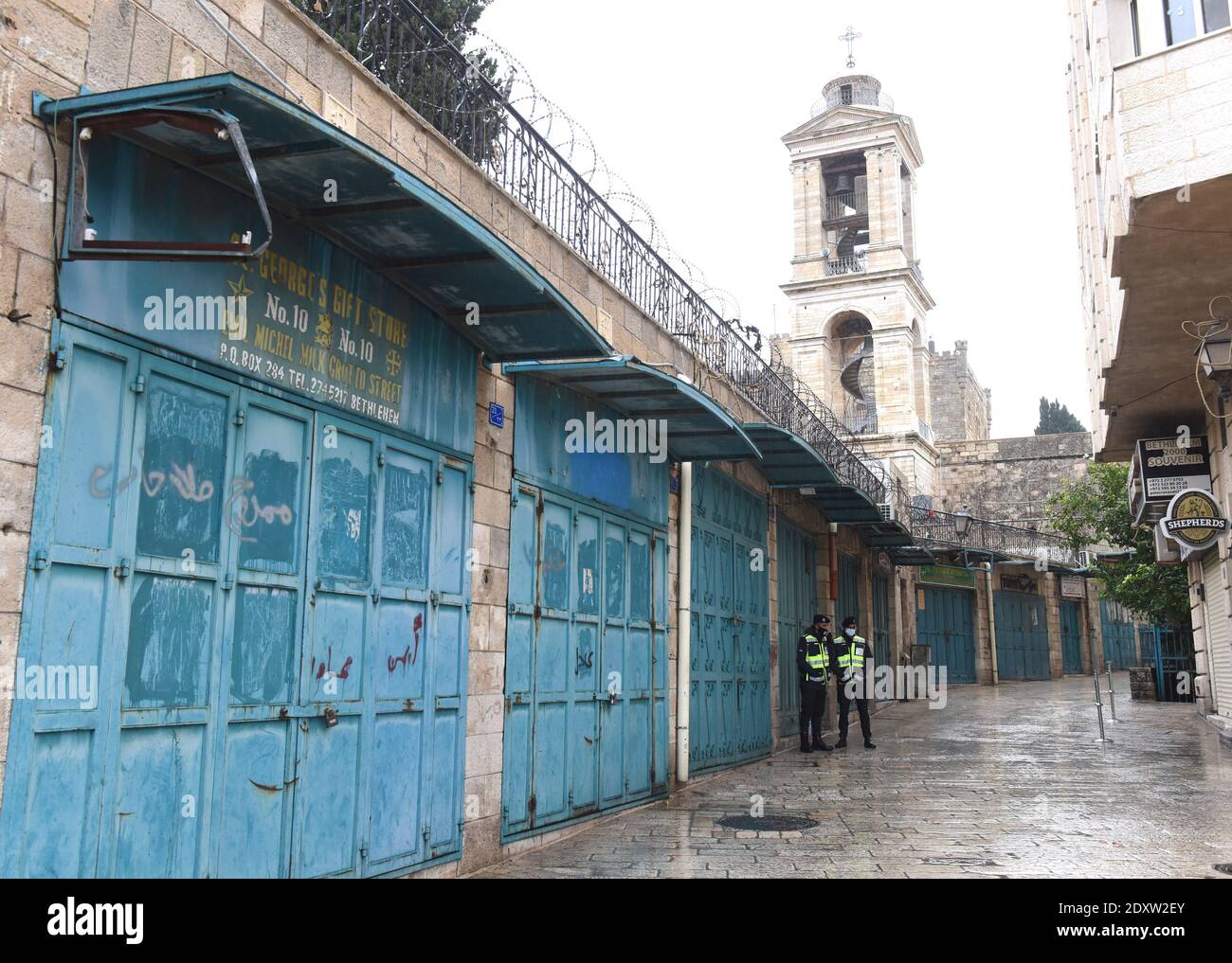 Bethléem, Cisjordanie. 24 décembre 2020. La police palestinienne se tient sous la pluie dans une rue vide près de l'église de la Nativité, la veille de Noël à Bethléem, en Cisjordanie, le jeudi 24 décembre 2020. La pandémie COVID-19 a frappé la ville biblique de naissance de Jésus au début du mois de mars, ce qui a entraîné la fermeture des frontières et l'absence de touristes pendant neuf mois. Photo par Debbie Hill/UPI crédit: UPI/Alay Live News Banque D'Images
