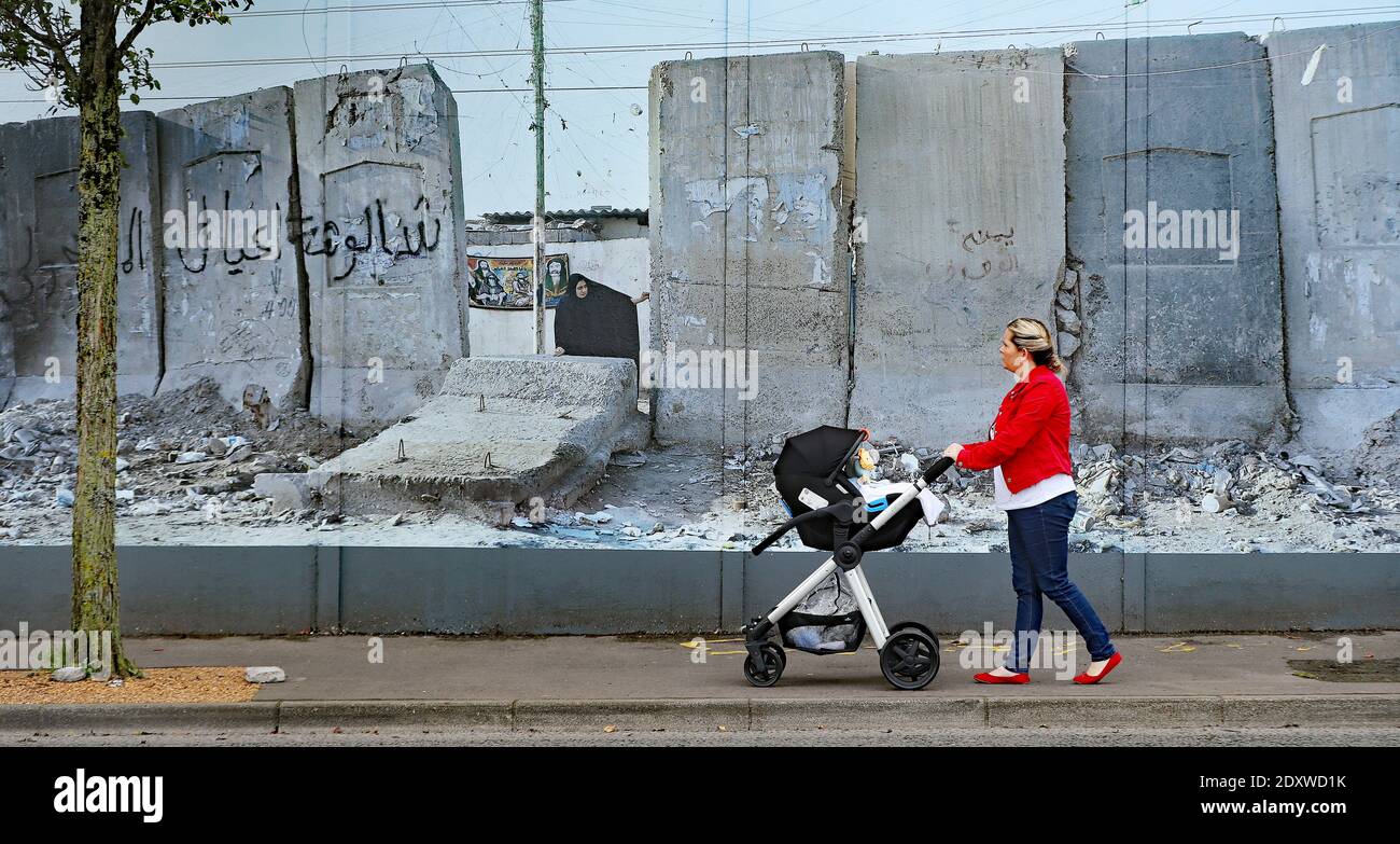 Photo du dossier datée du 30/09/19 d'une femme qui passe devant un mur de la paix de Belfast et qui expose des photos du photographe allemand Kai Wiedenhofer des murs frontaliers du monde, devant le Brexit. Le Royaume-Uni et l'UE sont parvenus à un accord commercial post-Brexit. Banque D'Images