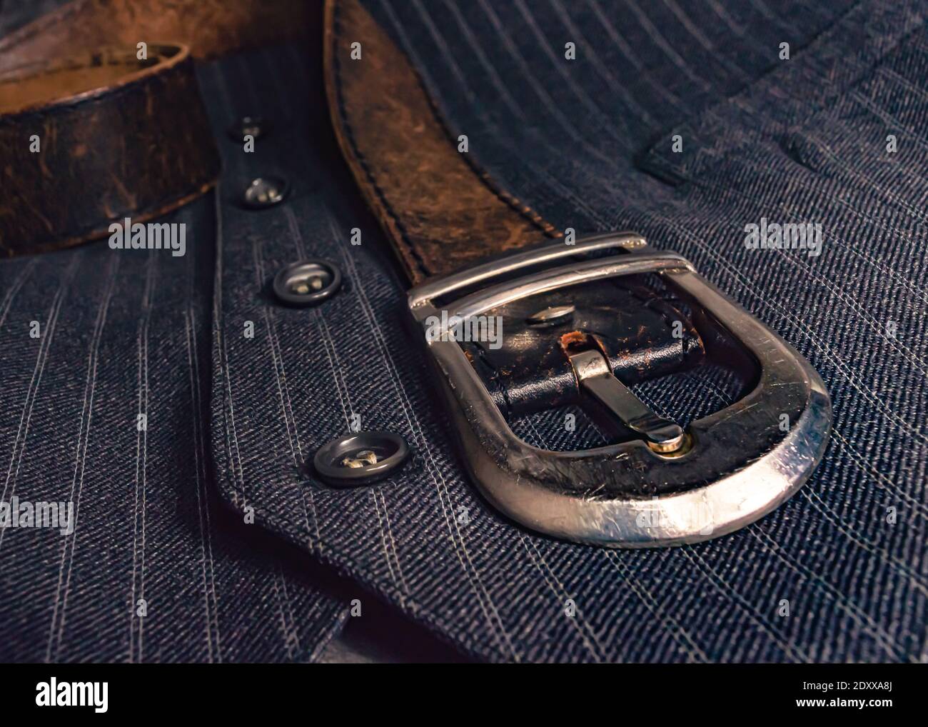 Gros plan d'une boucle de ceinture chromée d'une ceinture en cuir sur un  gilet rayé gris Photo Stock - Alamy