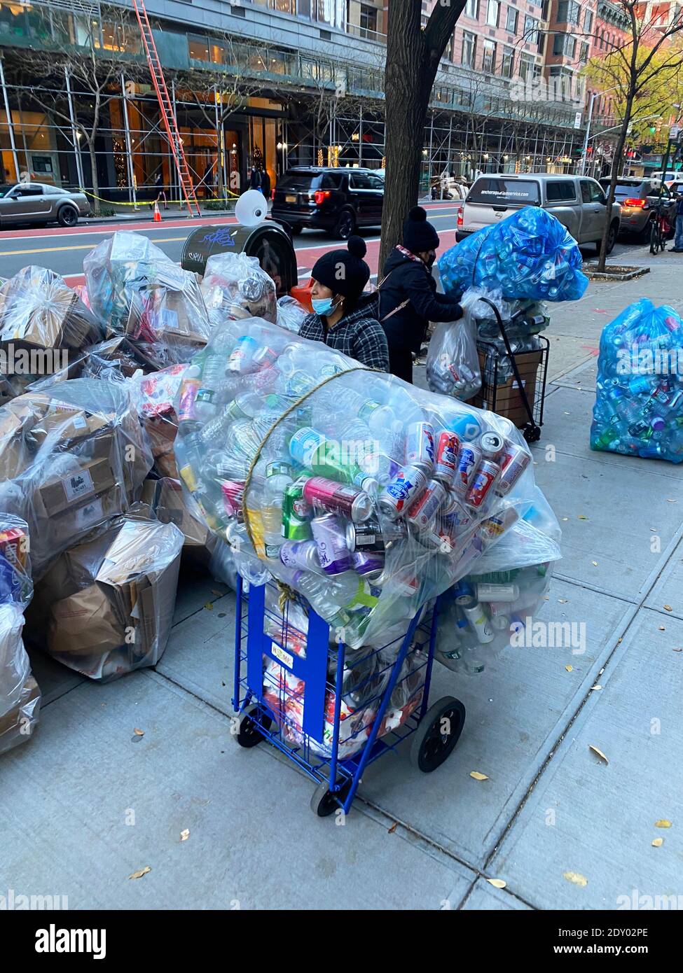 Les femmes travaillent dur à recueillir des bouteilles et des canettes pour les transformer en espèces dans la rue de Manhattan, New York. Banque D'Images