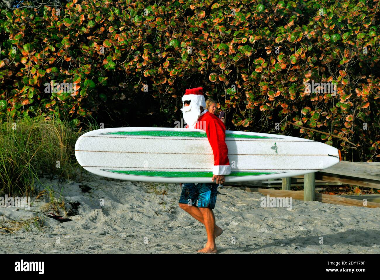 Indialantic, Comté de Brevard, Floride, États-Unis. 24 décembre 2020. Le Père Noël 2020 a été un événement réduit cette année en raison de Covid-19. Un petit groupe vêtu d'une tenue de Noël s'est aventuré dans les vagues de l'océan Atlantique alors que quelques centaines de spectateurs regardaient depuis la plage. Crédit : Julian Leek/Alay Live News Banque D'Images