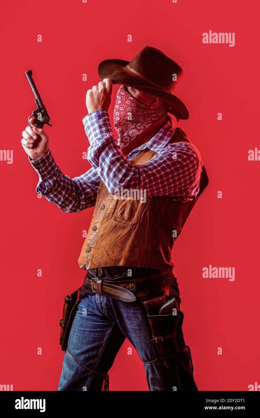 Bandit américain dans le masque, homme occidental avec chapeau. Homme portant un chapeau de cow-boy, arme à feu. L'Ouest, les armes. Cow-boy américain. Cowboy portant un chapeau. La vie occidentale. Le gars Banque D'Images