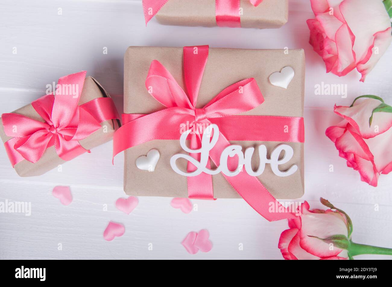 Le mot amour en lettres blanches sur les boîtes-cadeaux avec rubans roses. Concept d'amour, Saint-Valentin. Banque D'Images