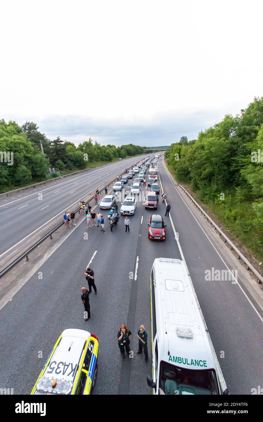 La circulation s'est arrêtée sur l'autoroute M11 en raison d'un grave accident de la route qui a fermé l'autoroute dans les deux directions. Les gens hors de leur voiture. Stationnaire Banque D'Images