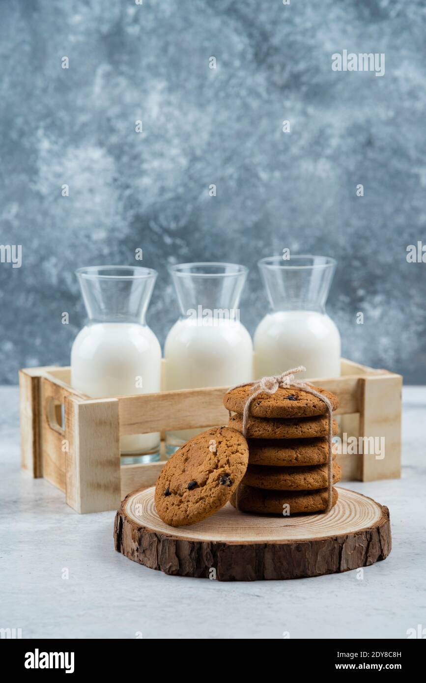 Trois pots de lait en verre et une pile de biscuits table en marbre Banque D'Images