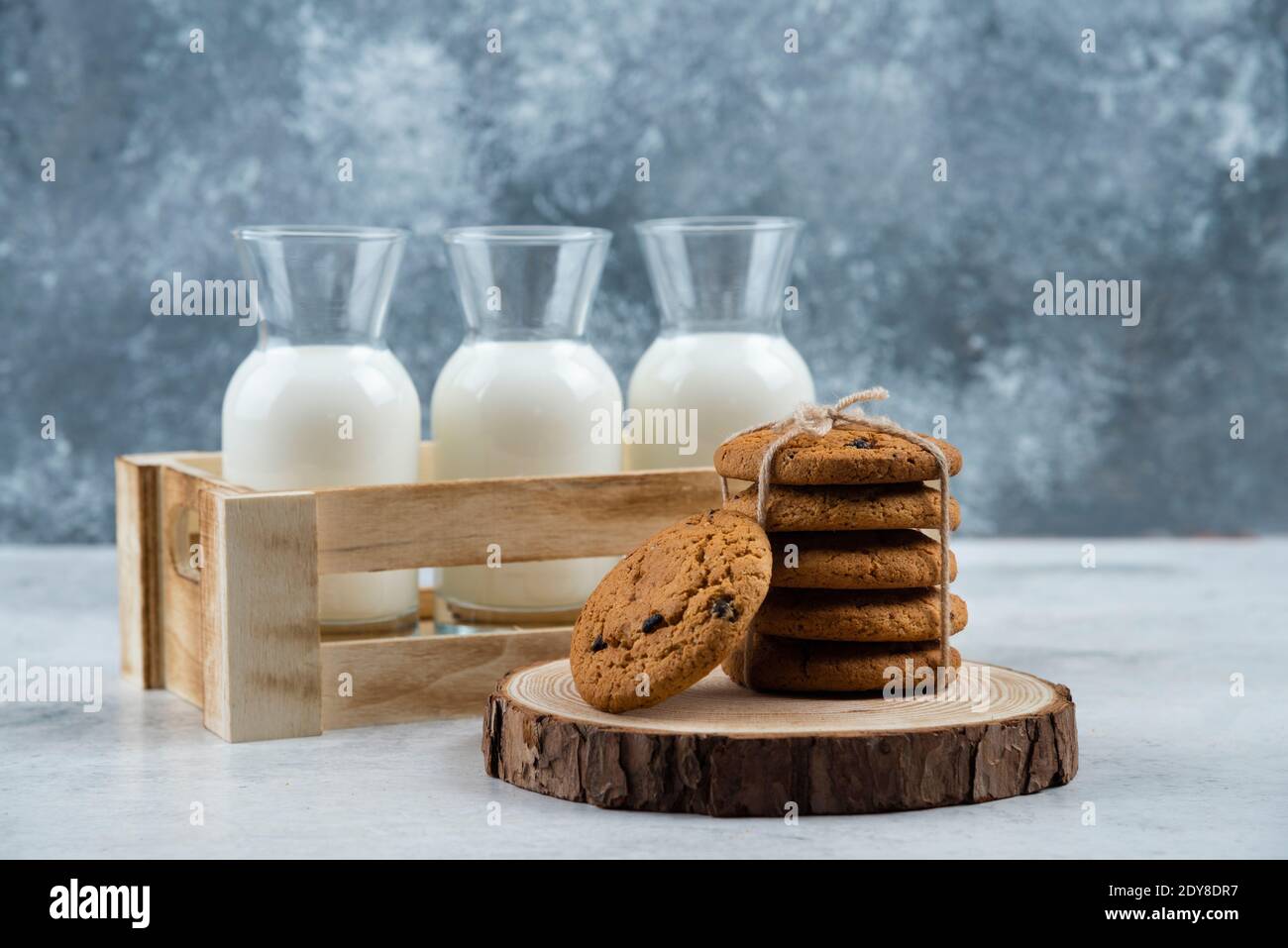 Trois pots de lait en verre et une pile de biscuits table en marbre Banque D'Images