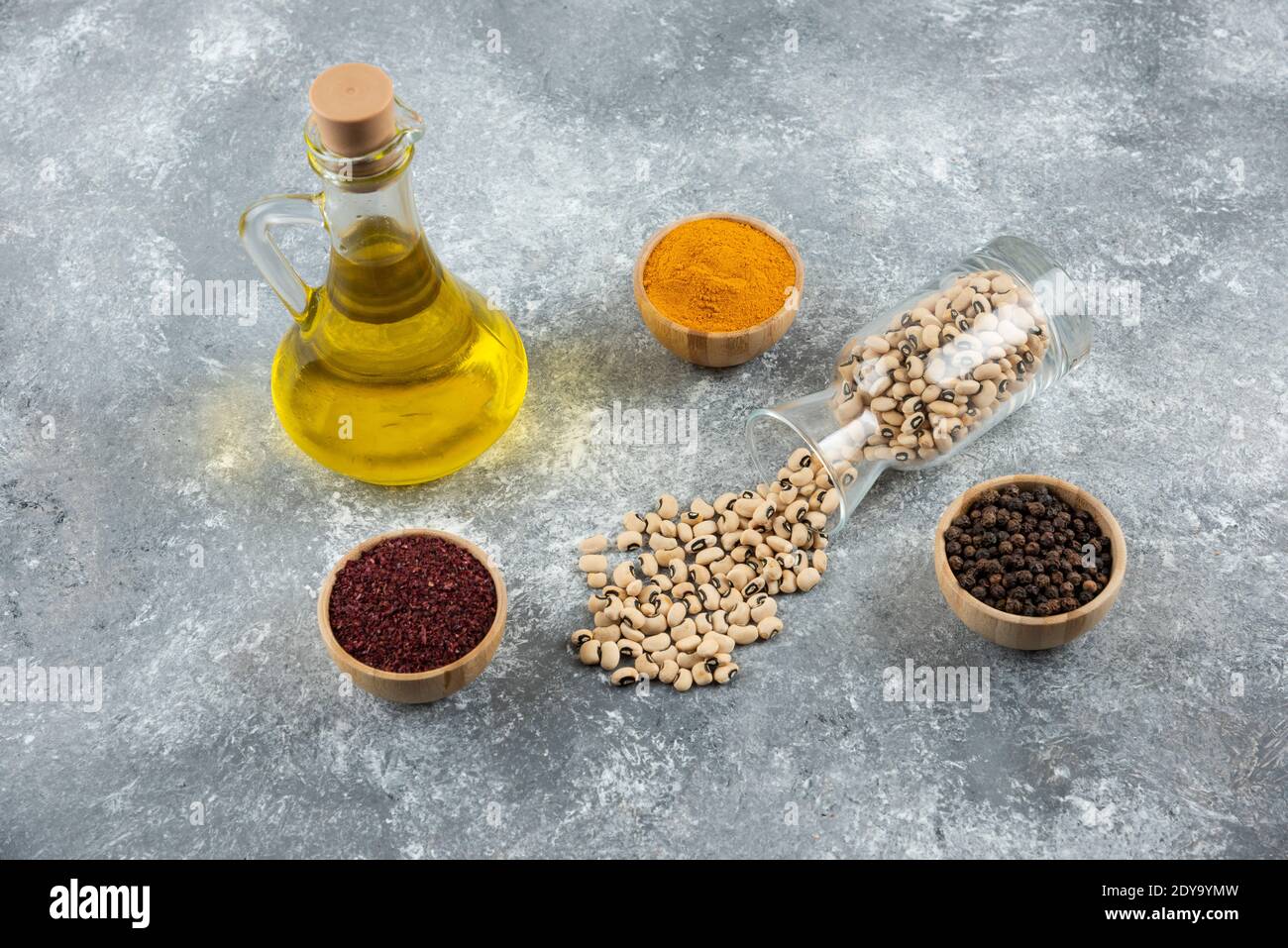 Un pot en verre avec haricots blancs crus sur un arrière-plan gris Banque D'Images