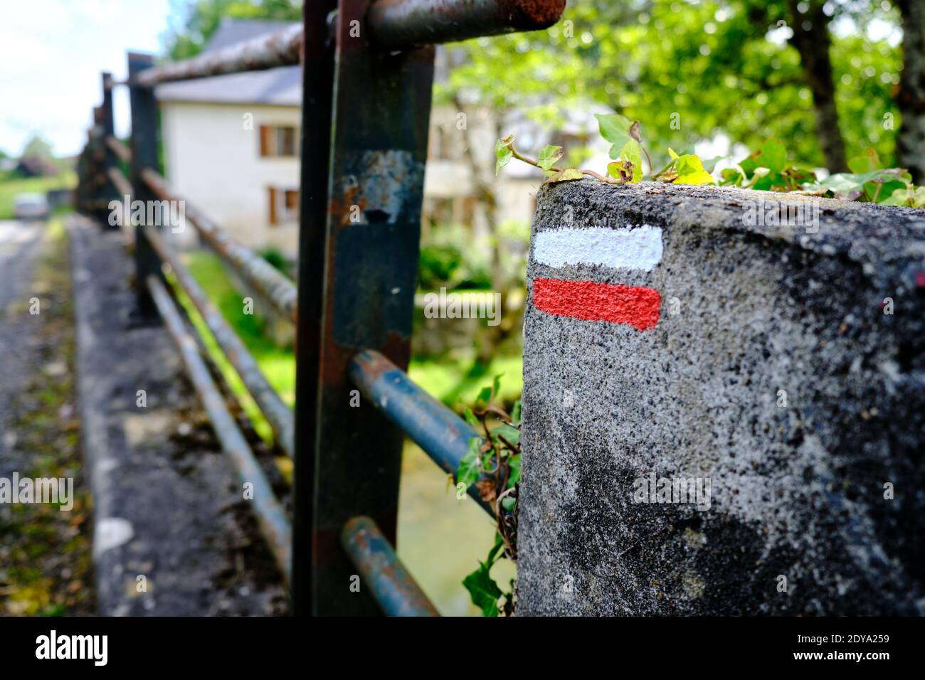 Marqueur de chemin blanc et rouge sur un mur latéral le long d'un sentier de campagne indiquant le chemin d'une randonnée en France, le long des grands sentiers de randonnée Banque D'Images