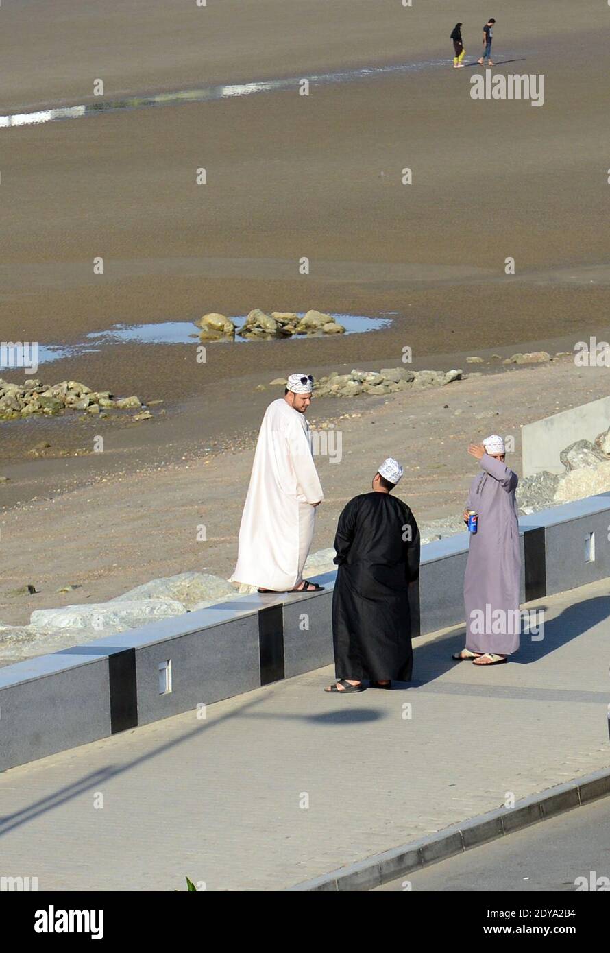 Des hommes omanais se socialisent sur la promenade de la plage de Qurum à Muscat, Oman. Banque D'Images