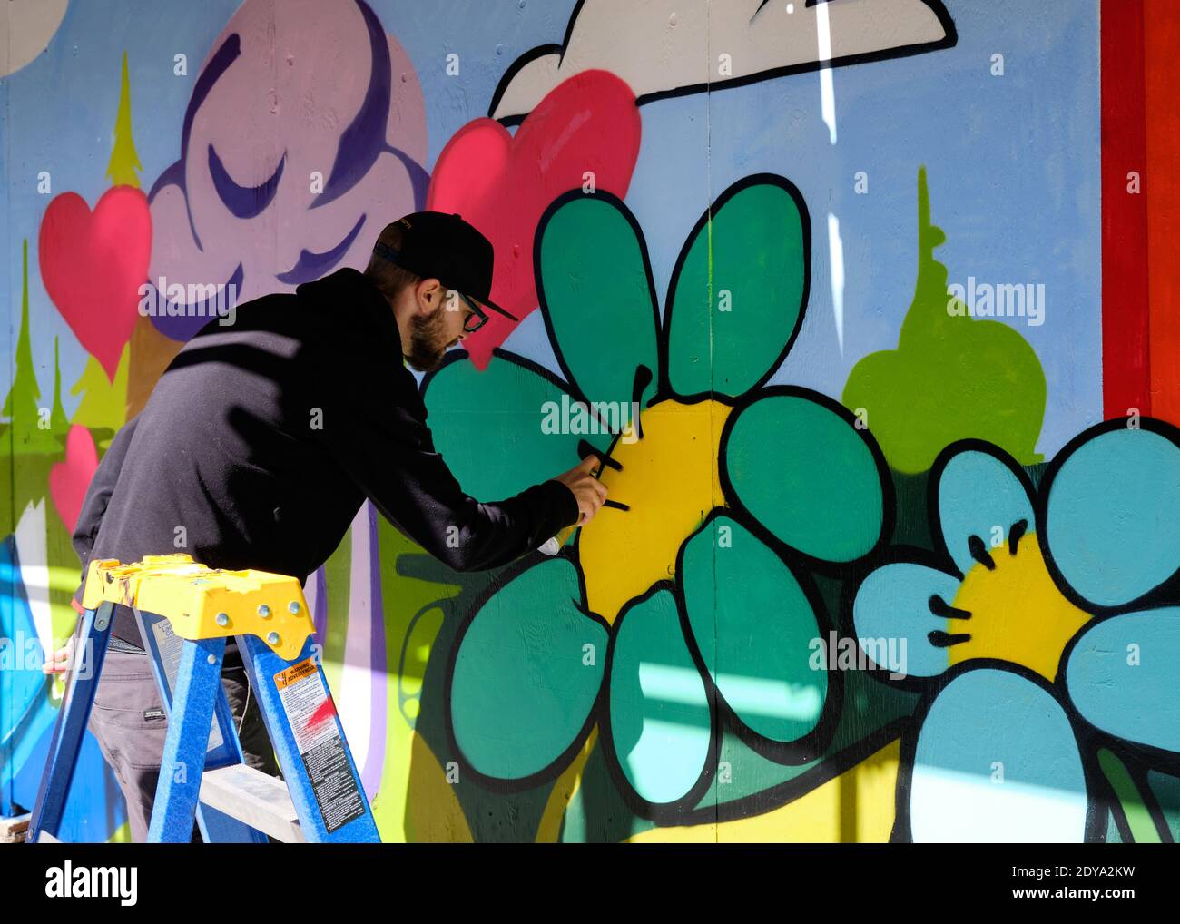 Artiste de rue travaillant sur une fresque murale aux couleurs vives À Ottawa Banque D'Images