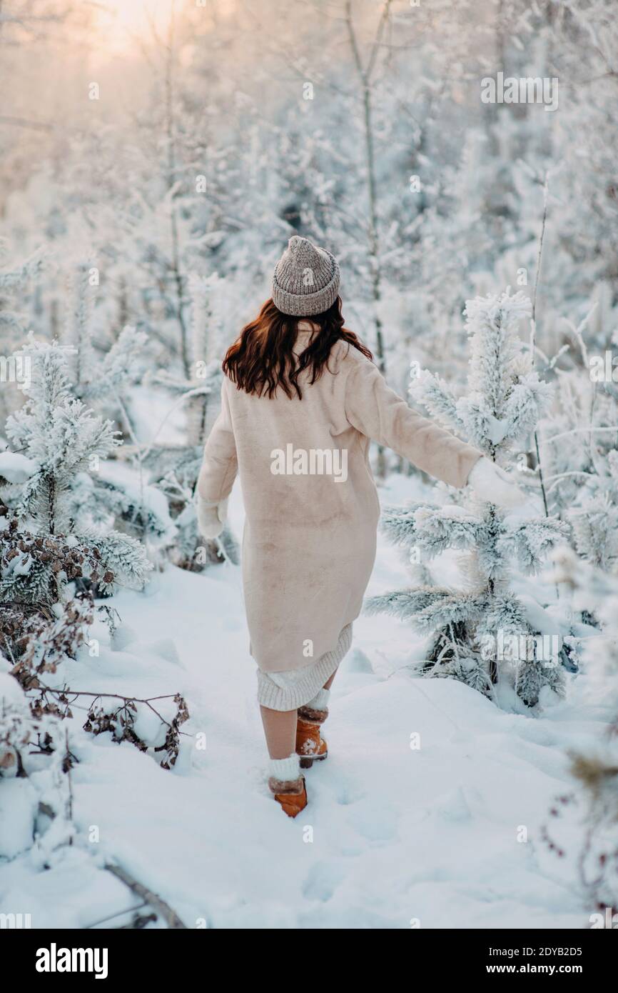 Une fille dans UN manteau de fausse fourrure beige marche à travers UNE  forêt de neige. Look hiver tendance. Élégant Photo Stock - Alamy