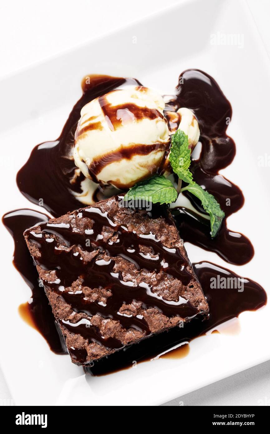dessert au chocolat végétalien avec glace à la vanille sans lait de coco crème avec sauce caramel sur fond blanc en studio Banque D'Images