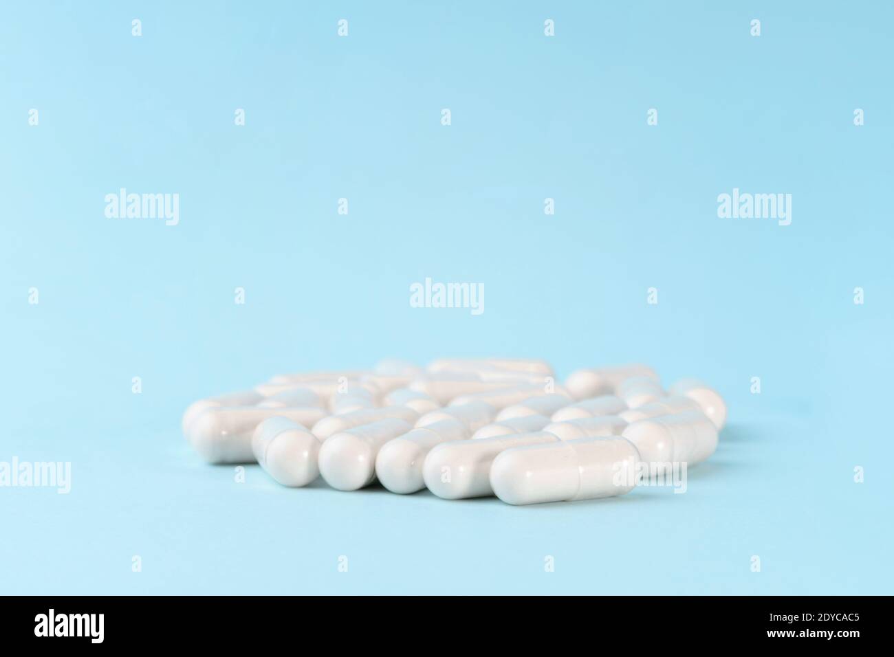 Capsules de médicaments ou de suppléments sur la surface bleue. Pilules pharmaceutiques, comprimés et vitamines. Banque D'Images