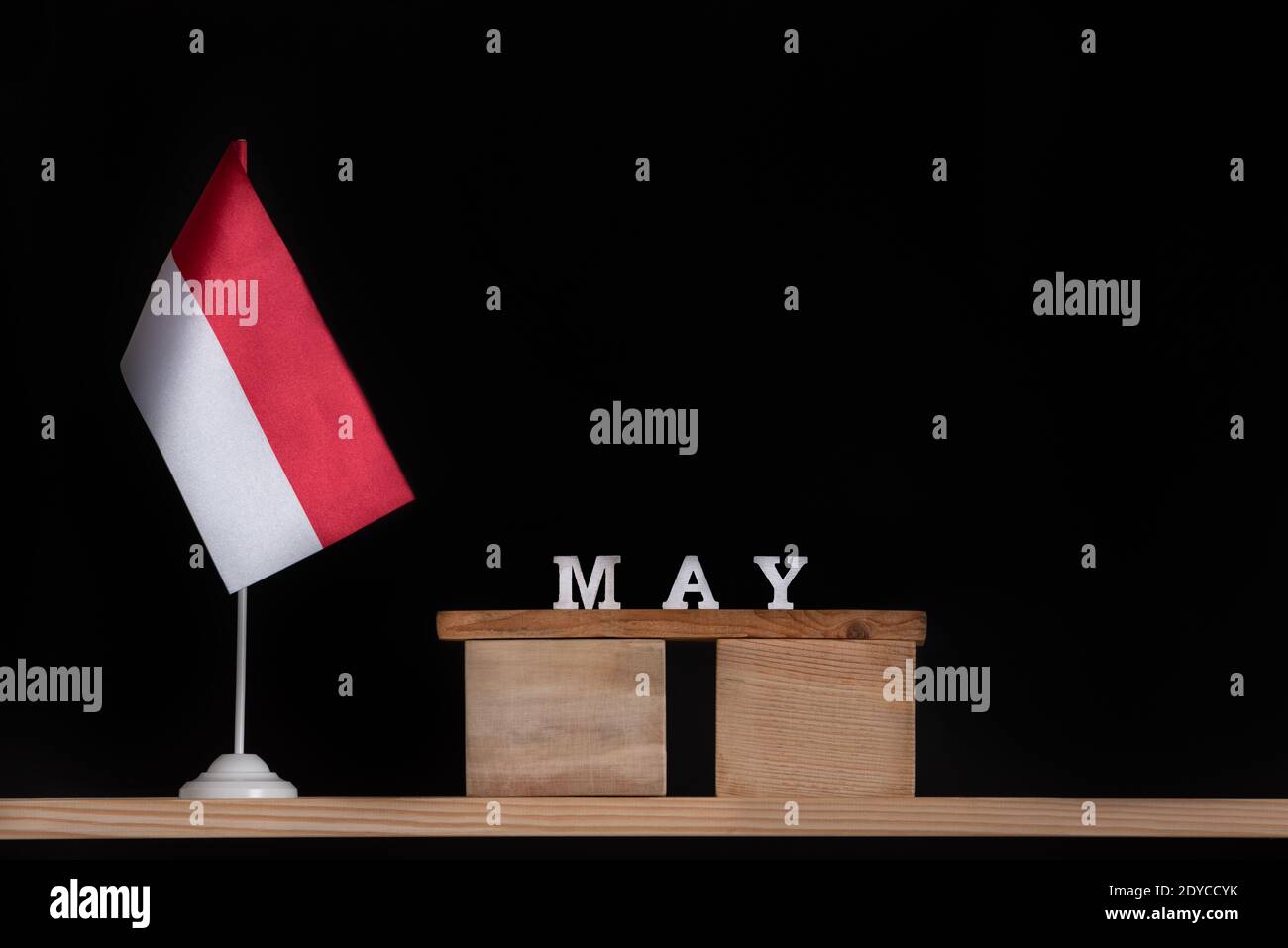 Calendrier en bois de mai avec drapeau polonais sur fond noir. Vacances de Pologne en mai Banque D'Images