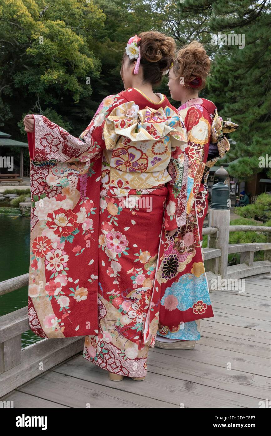 Deux jeunes femmes dans une belle tenue traditionnelle qui regarde sur le pont Geishun-kyo, Ritsurin Garden, Takamatsu, Japon Banque D'Images
