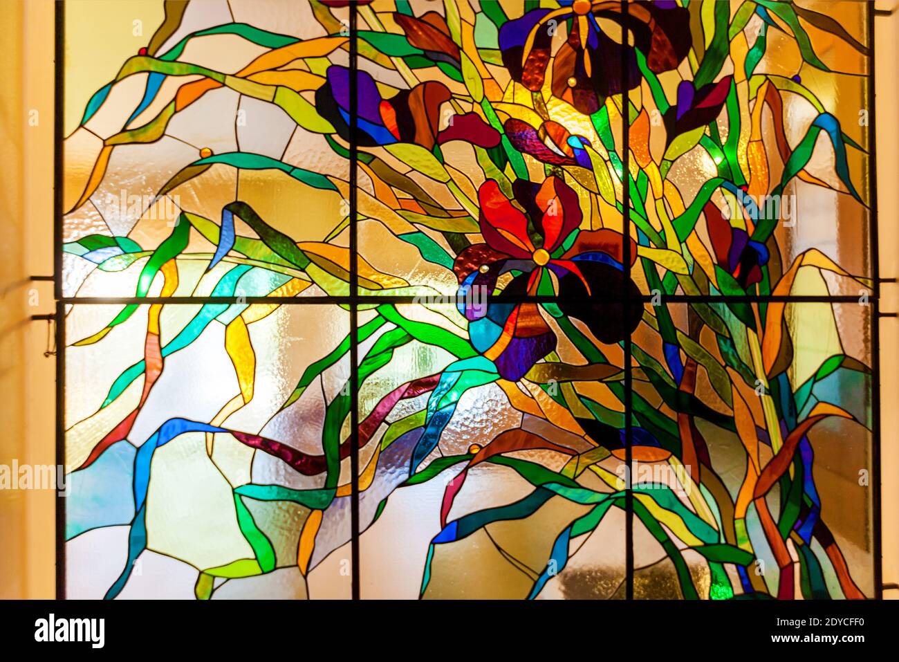 Image d'une fleur multicolore de vitraux colorés dans une fenêtre. Vitraux aux fleurs multicolores Banque D'Images