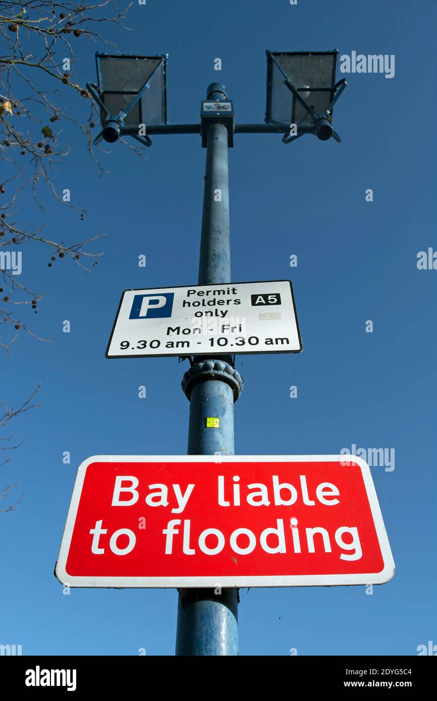 panneaux sur un lampadaire de style victorien au-dessus d'une aire de stationnement sur le remblai de putney, londres, angleterre, avec règles de stationnement et avertissement potentiel d'inondation Banque D'Images