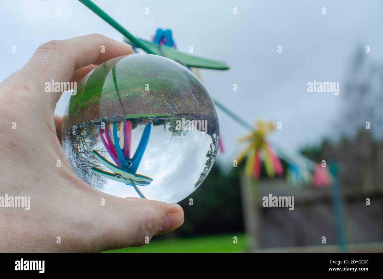 Se fixe sur une ligne de lavage dans un jardin vu à l'envers dans une boule de cristal de verre qui agit comme une lentille et provoque la réfraction. Banque D'Images