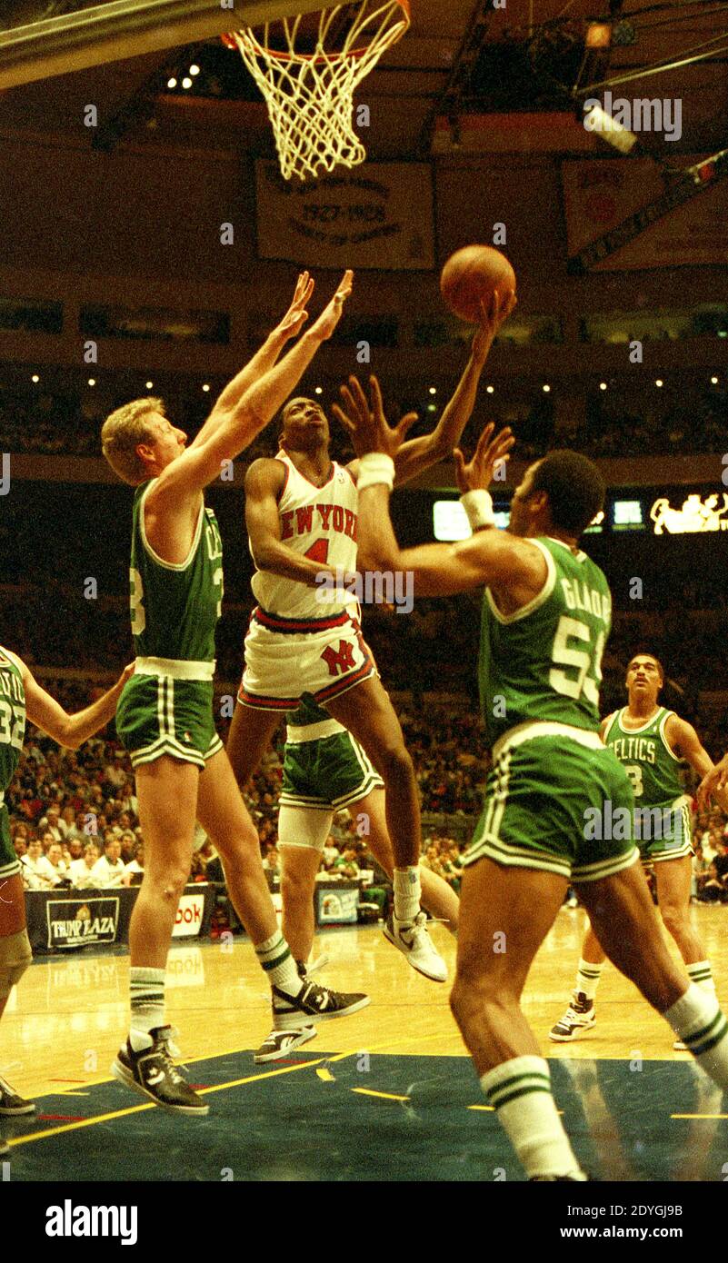 Larry Bird, des Boston Celtics, défend contre une mise en scène par Johnny Newman des New York Knicks lors d'un match au Madison Square Garden le 26 mars 1988, alors que Artis Gilmore des Celtics est en position pour le rebond. Banque D'Images
