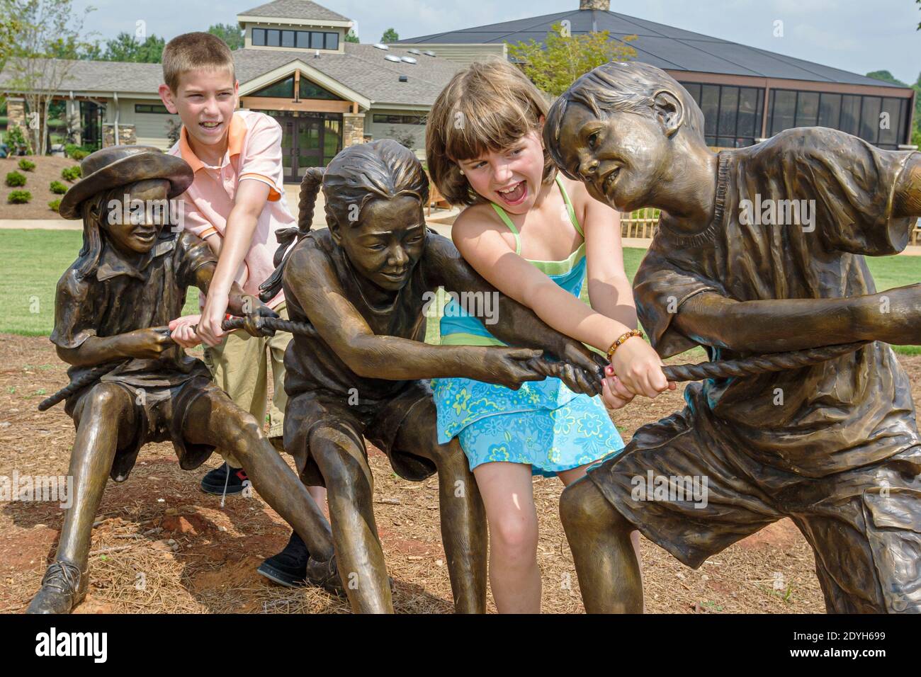 Huntsville Alabama, jardins botaniques jardins extérieurs pour enfants, jeune fille tug de la statue de sculpture de guerre aidant à tirer, Banque D'Images