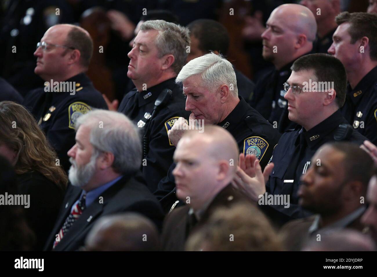 Les policiers de Boston écoutent tandis que Barack Obama parle lors d'un service de prière interconfessionnel pour les victimes de l'attaque du marathon de Boston intitulée « Healing Our City », à la cathédrale de la Sainte-Croix de Boston, Massachusetts, États-Unis, le 18 avril 2013. Les autorités chargées de l'enquête sur l'attaque du marathon de Boston ont déplacé leur attention vers la localisation de la personne qui a déposé un sac noir et qui s'est éloignée juste avant le décollage des bombes. Les deux attentats à la bombe de Boston, 116 ans, qui se sont produits près de la ligne d'arrivée du marathon, ont causé la mort de trois personnes et plus de 170 autres blessés. Photo par Banque D'Images