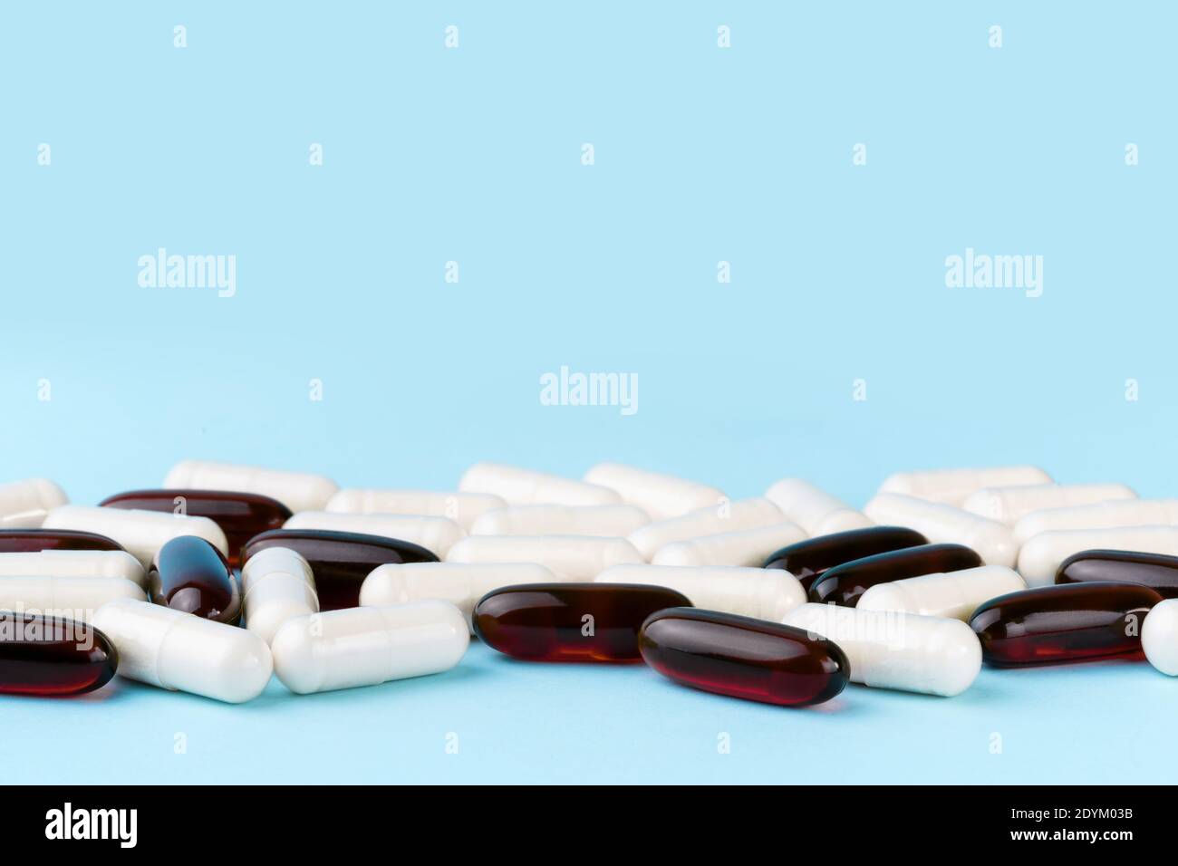 Pilules pharmaceutiques et vitamines. Capsules de médicaments ou de suppléments sur la surface bleue. Pile probiotique, inuline, glucosamine. Banque D'Images
