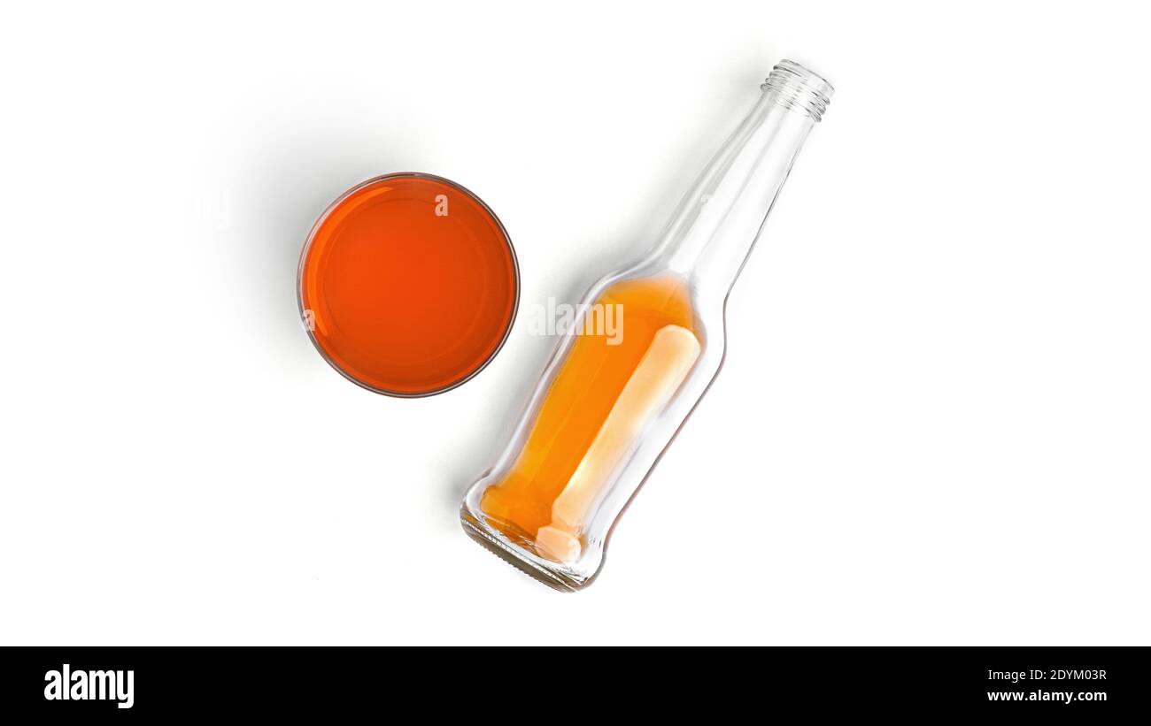 Une bouteille et un verre avec une boisson à l'orange sur fond blanc. Photo de haute qualité Banque D'Images