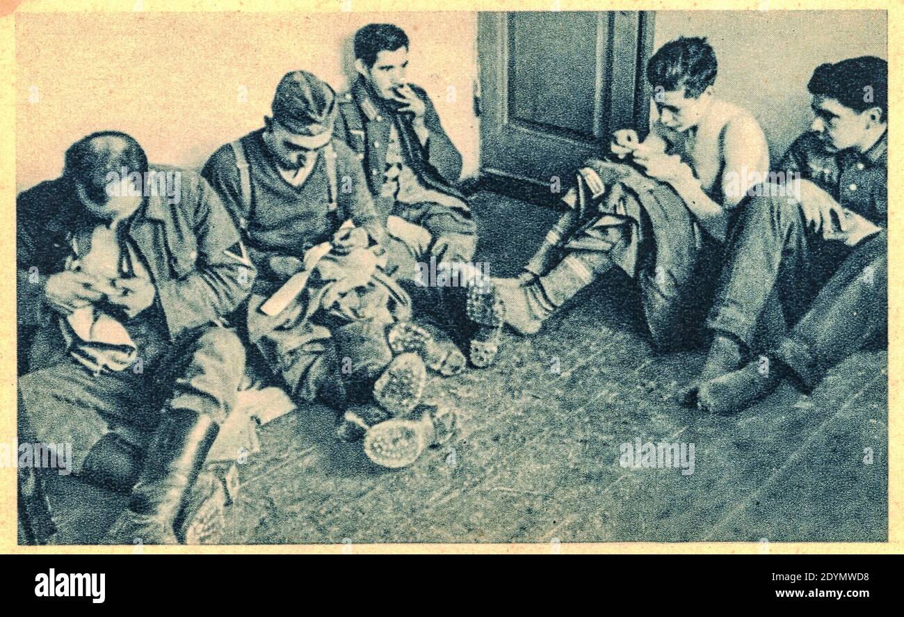 EUROPE DE L'EST - 1944: Prisonniers de guerre allemands en temps de silence. Temps de réparation des vêtements. Soldats allemands dans le camp de prisonniers de guerre. Archiver la photo en noir et blanc Banque D'Images