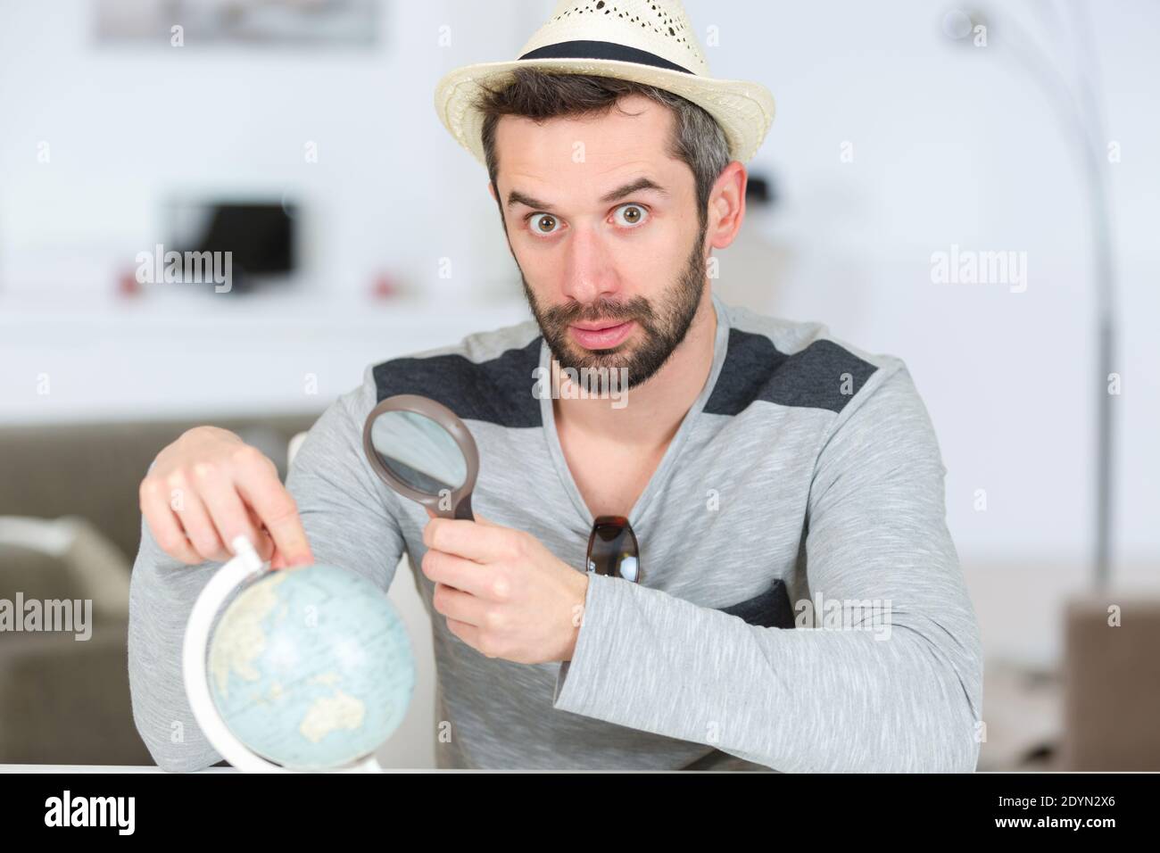homme regardant le globe de position avec la loupe Banque D'Images