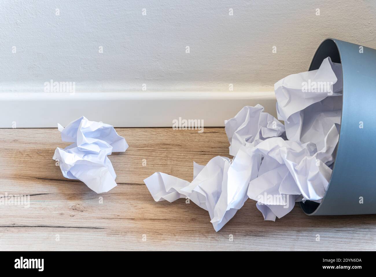 Papier poubelle. Papier froissé tombant dans le bac de recyclage, a été jeté dans le bac à paniers, débordant le papier de rebut dans le bac à déchets de bureau ancien arrière-plan en bois vue latérale avec l'espace de copie. Photo de haute qualité Banque D'Images