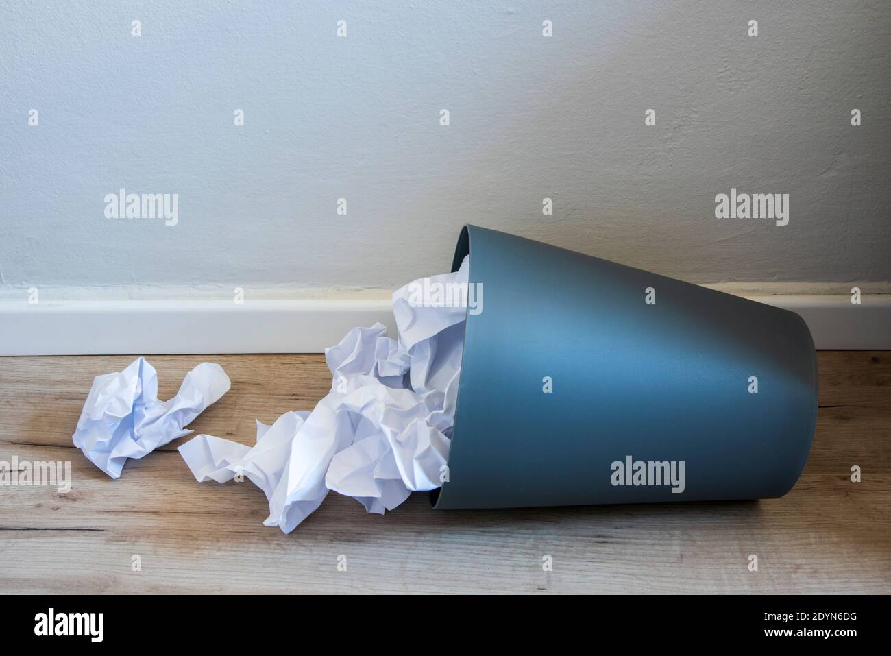 Papier poubelle. Papier froissé tombant dans le bac de recyclage, a été jeté dans le bac à paniers, débordant le papier de rebut dans le bac à déchets de bureau ancien arrière-plan en bois vue latérale avec l'espace de copie. Photo de haute qualité Banque D'Images