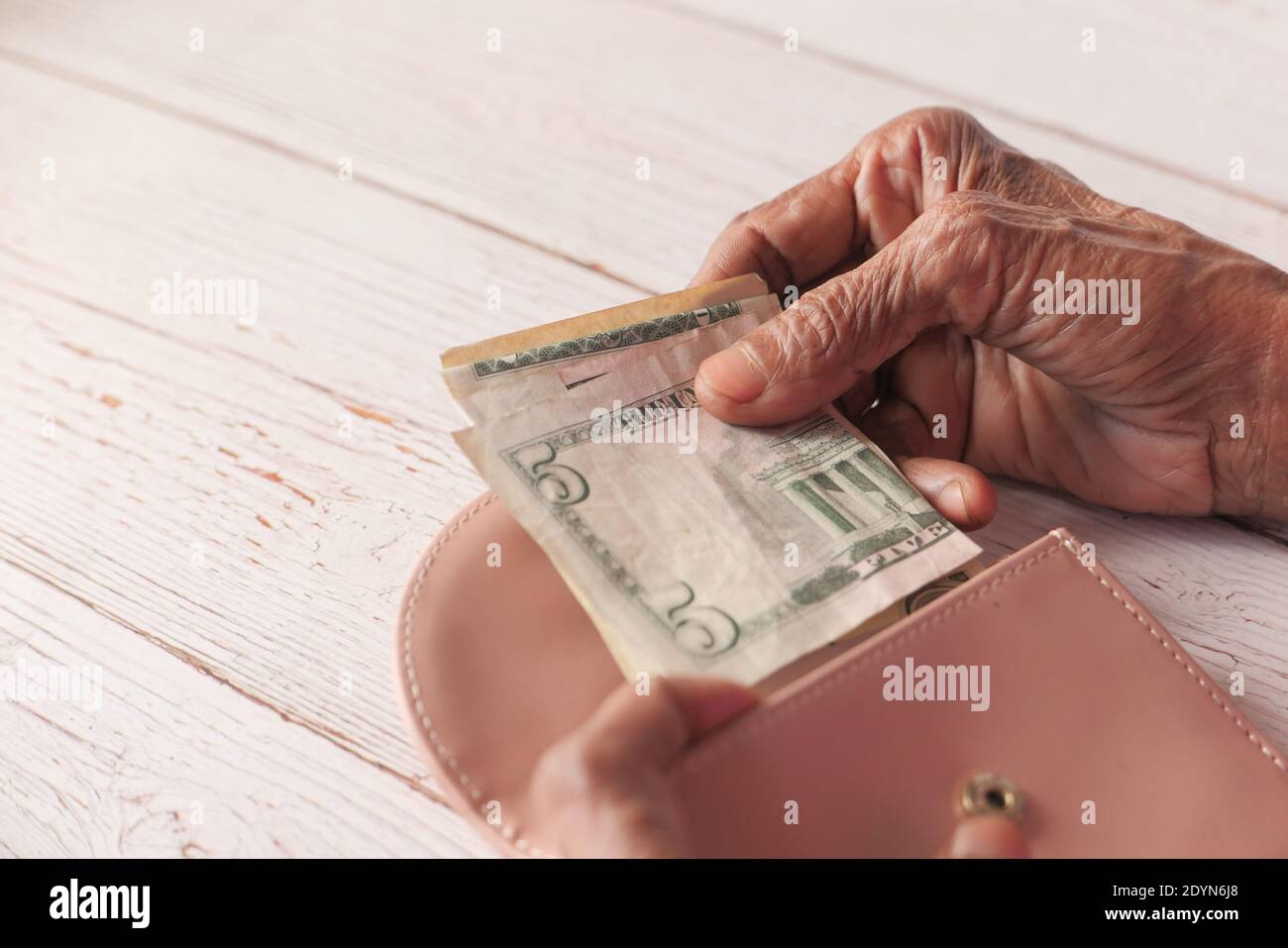 Gros plan des femmes âgées économisant de l'argent dans un portefeuille Banque D'Images