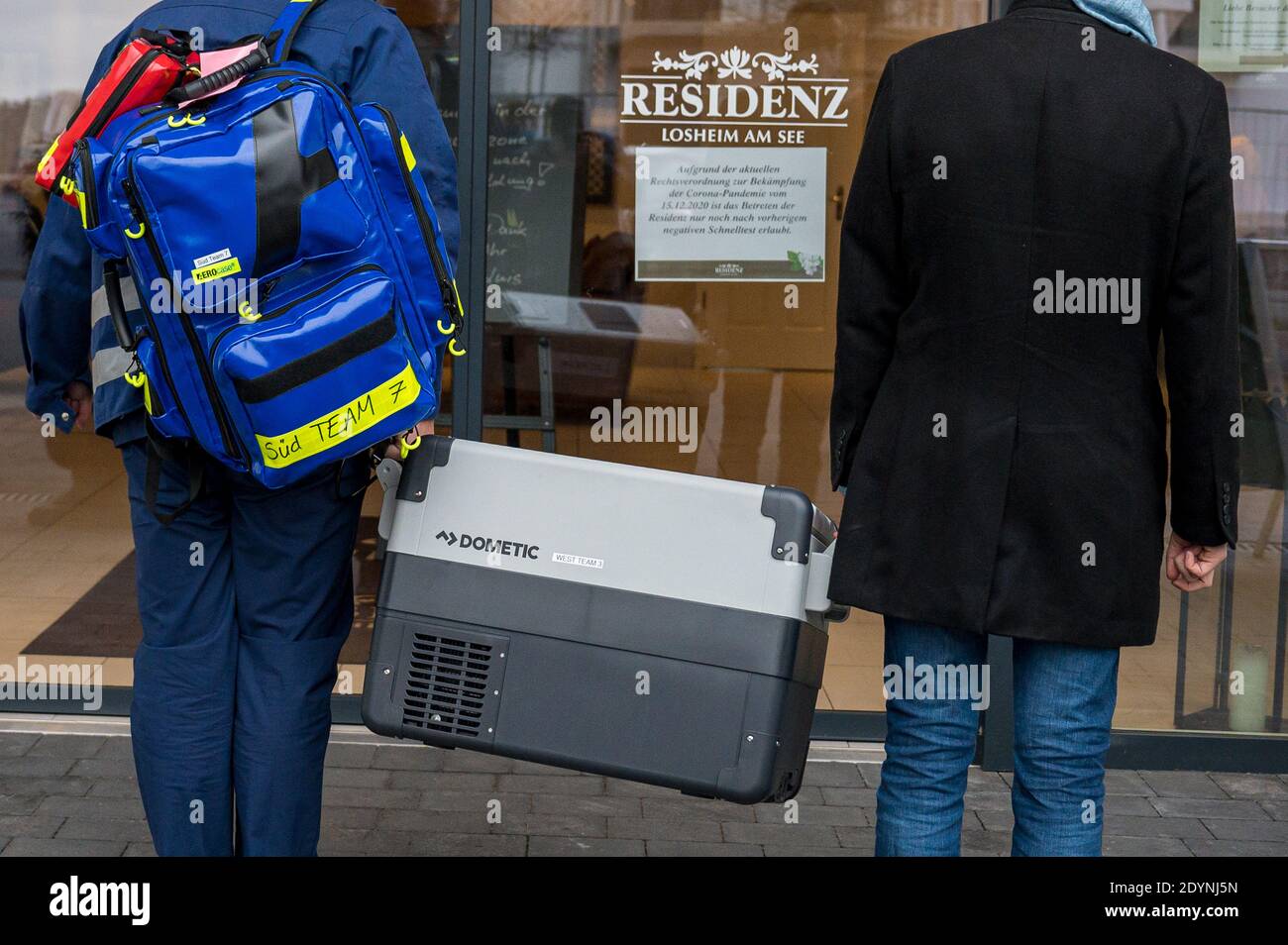 Losheim, Allemagne. 27 décembre 2020. Deux membres de l'équipe de vaccination sont debout avec le vaccin devant l'entrée de la résidence principale de Losheim am See. La vaccination de Corona avec le vaccin Biontech/Pfizer a commencé dimanche en Allemagne. Credit: Oliver Dietze/dpa/Alay Live News Banque D'Images