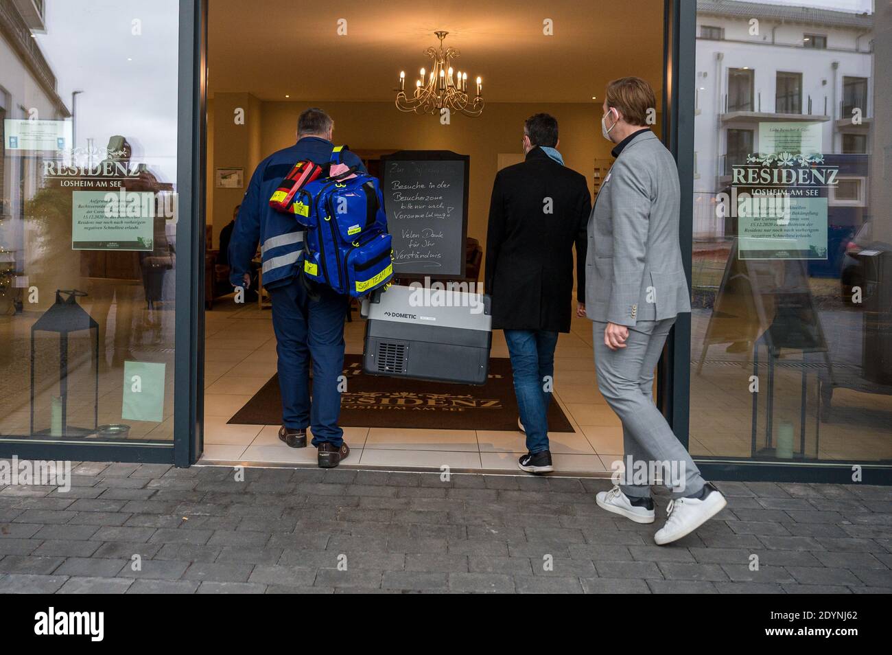 Losheim, Allemagne. 27 décembre 2020. Thorsten Sprengart (r), gérant de résidence, reçoit deux membres de l'équipe de vaccination avec le vaccin à l'entrée de la résidence principale de Losheim am See. Dimanche, la vaccination de Corona avec le vaccin de Biontech/Pfizer a commencé en Allemagne. Credit: Oliver Dietze/dpa/Alay Live News Banque D'Images
