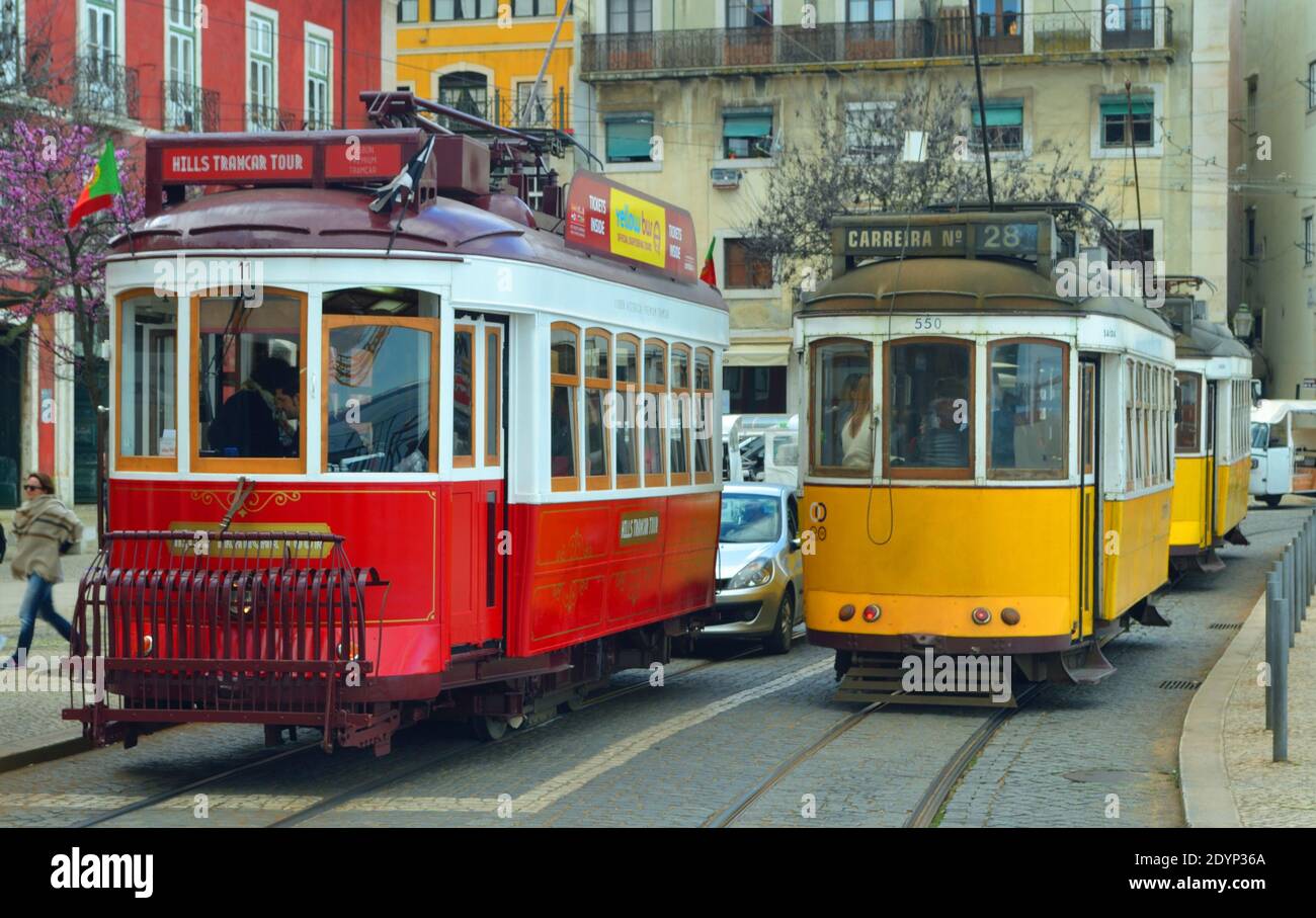 Trois vieux trams rouges et jaunes traditionnels de Lisbonne sur Largo das Portas do sol bloquant la circulation. Banque D'Images