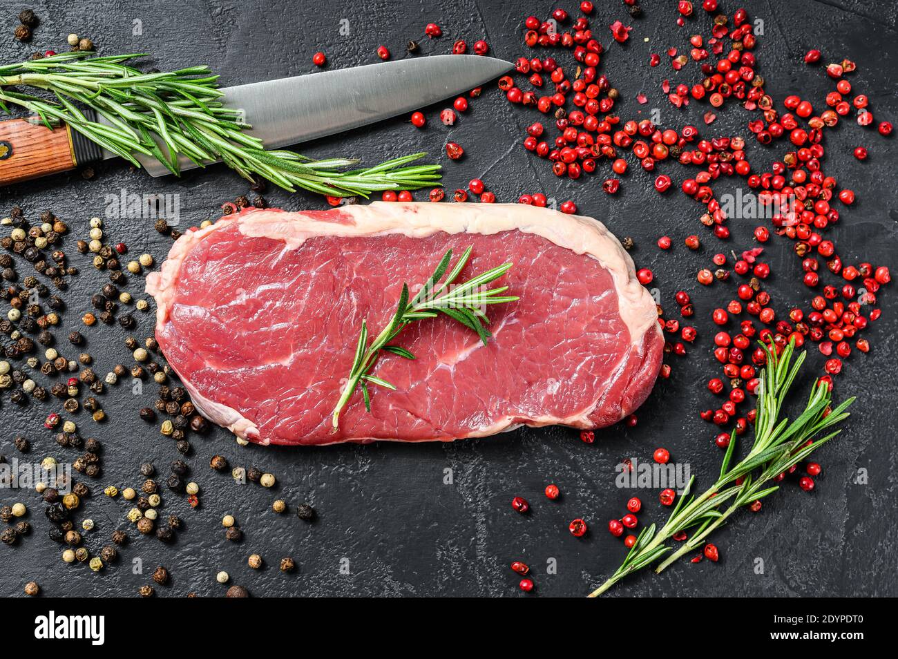 Striploin, strip loin steak ou New York. Bœuf cru. Arrière-plan noir. Vue de dessus Banque D'Images