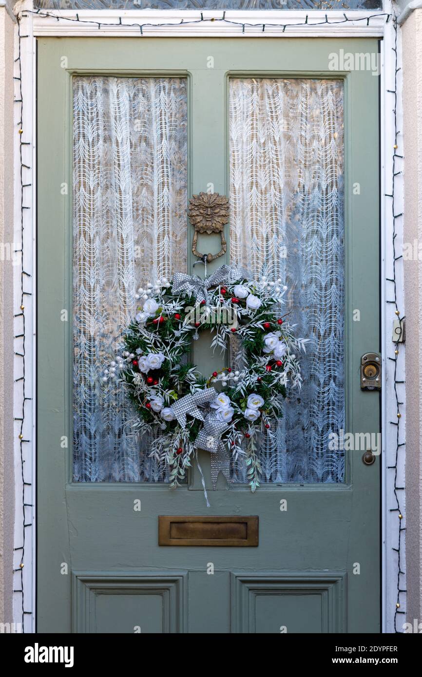 Une décoration de couronne de Noël accrochée sur la porte avant de une maison Banque D'Images