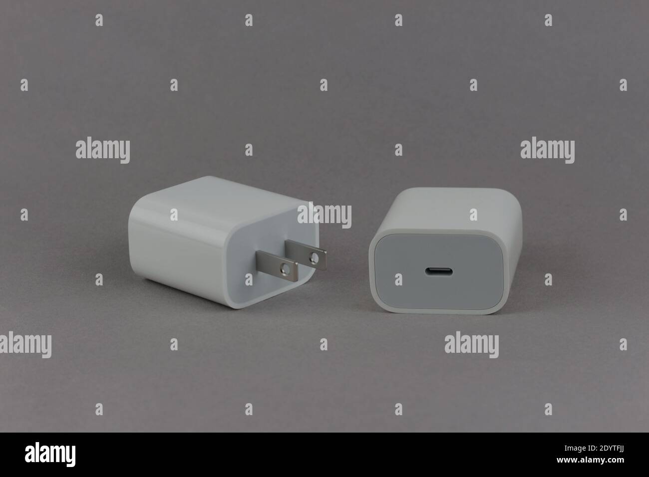 Adaptateur secteur blanc USB-C de 20 watts, avant et arrière, sur fond gris Banque D'Images