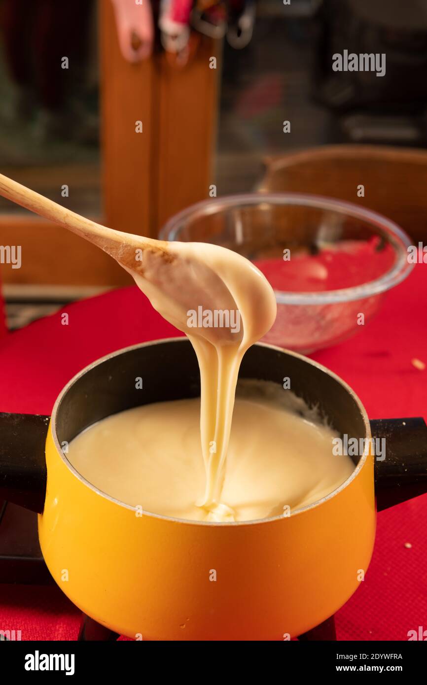 Le fromage suisse est remué et testé pour le dîner de fondue Banque D'Images