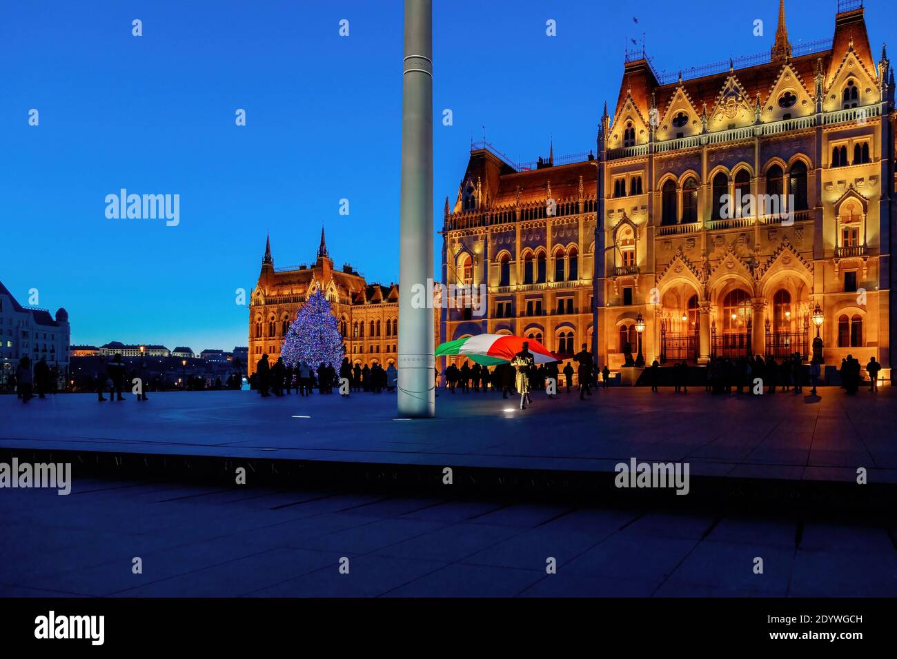 Budapest, Hongrie - 26 décembre 2020 : drapeau du soir s'abaissant à Noël devant le Parlement avec l'arbre de Noël en arrière-plan. Banque D'Images