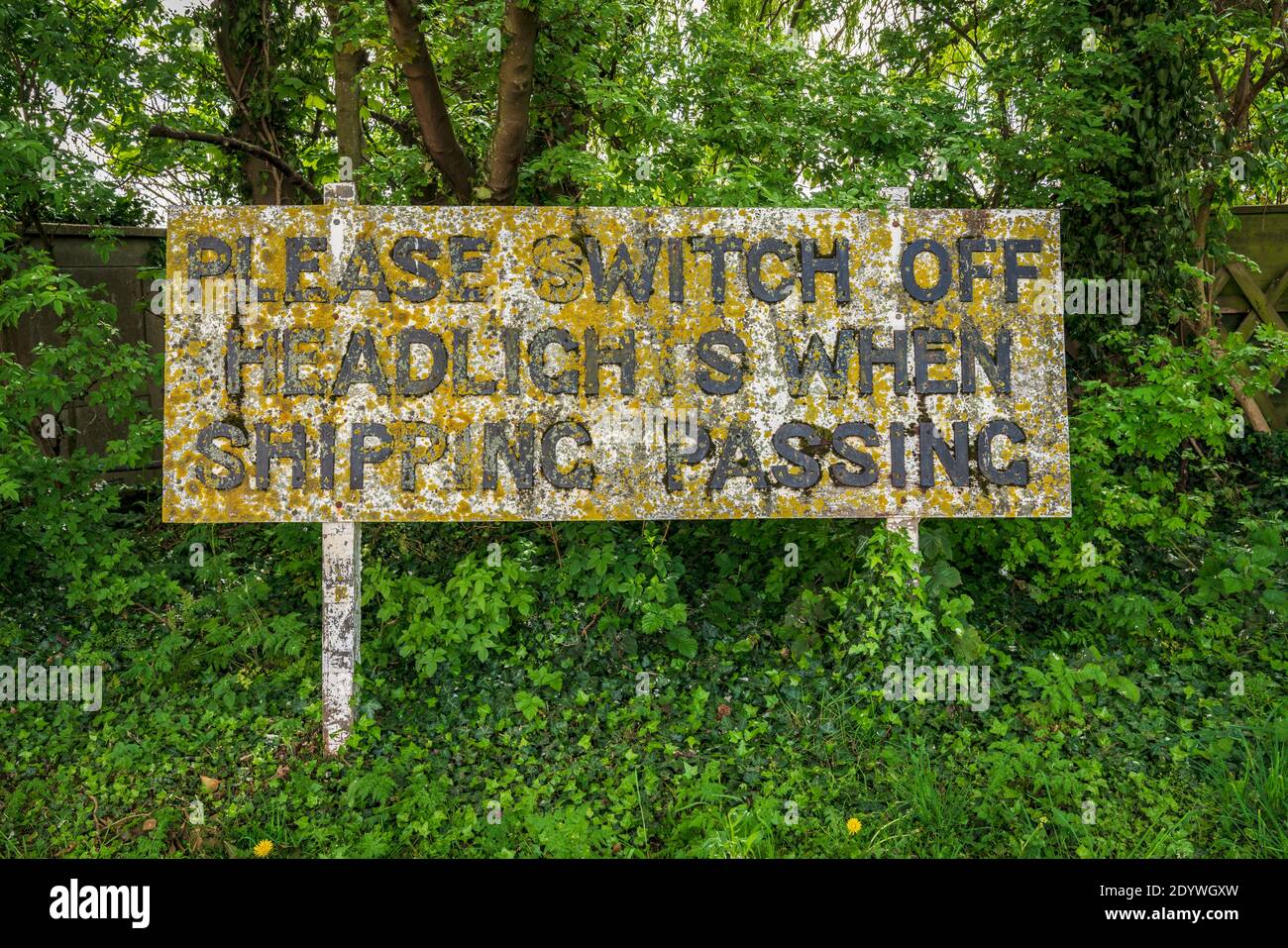 Signe décoloré: Veuillez éteindre les phares lors de l'expédition passant, vu à Sutton Bridge, Lincolnshire, Angleterre, Royaume-Uni Banque D'Images