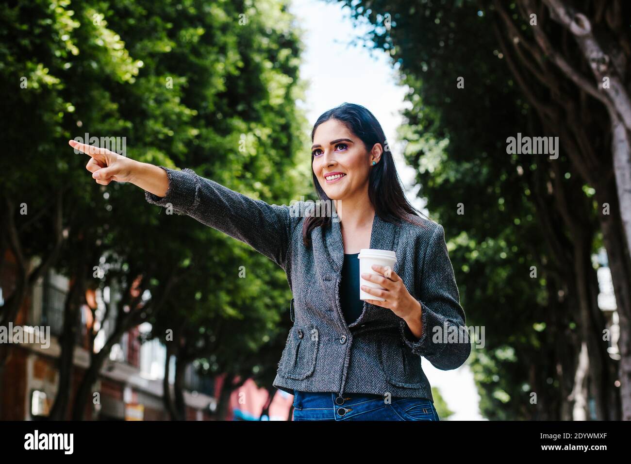 une femme latine en plein air dans la ville qui se hante d'un taxi une ville coloniale d'amérique latine Banque D'Images