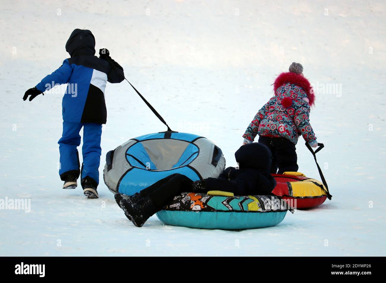Les enfants s'amusent sur les tubes de neige. Les enfants font du tubing, des animations hivernales Banque D'Images