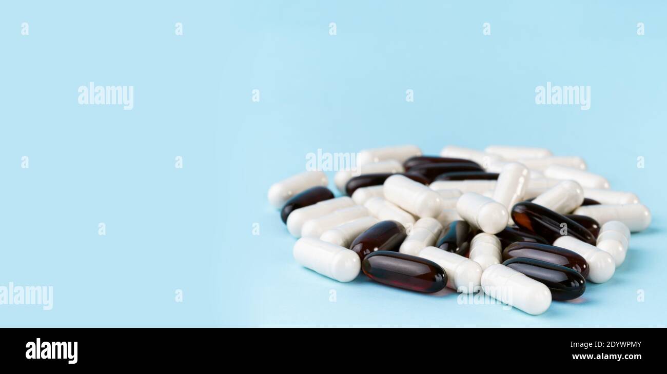 Pilules pharmaceutiques et vitamines. Capsules de médicaments ou de suppléments sur la surface bleue. Pile probiotique, inuline, glucosamine. Banque D'Images