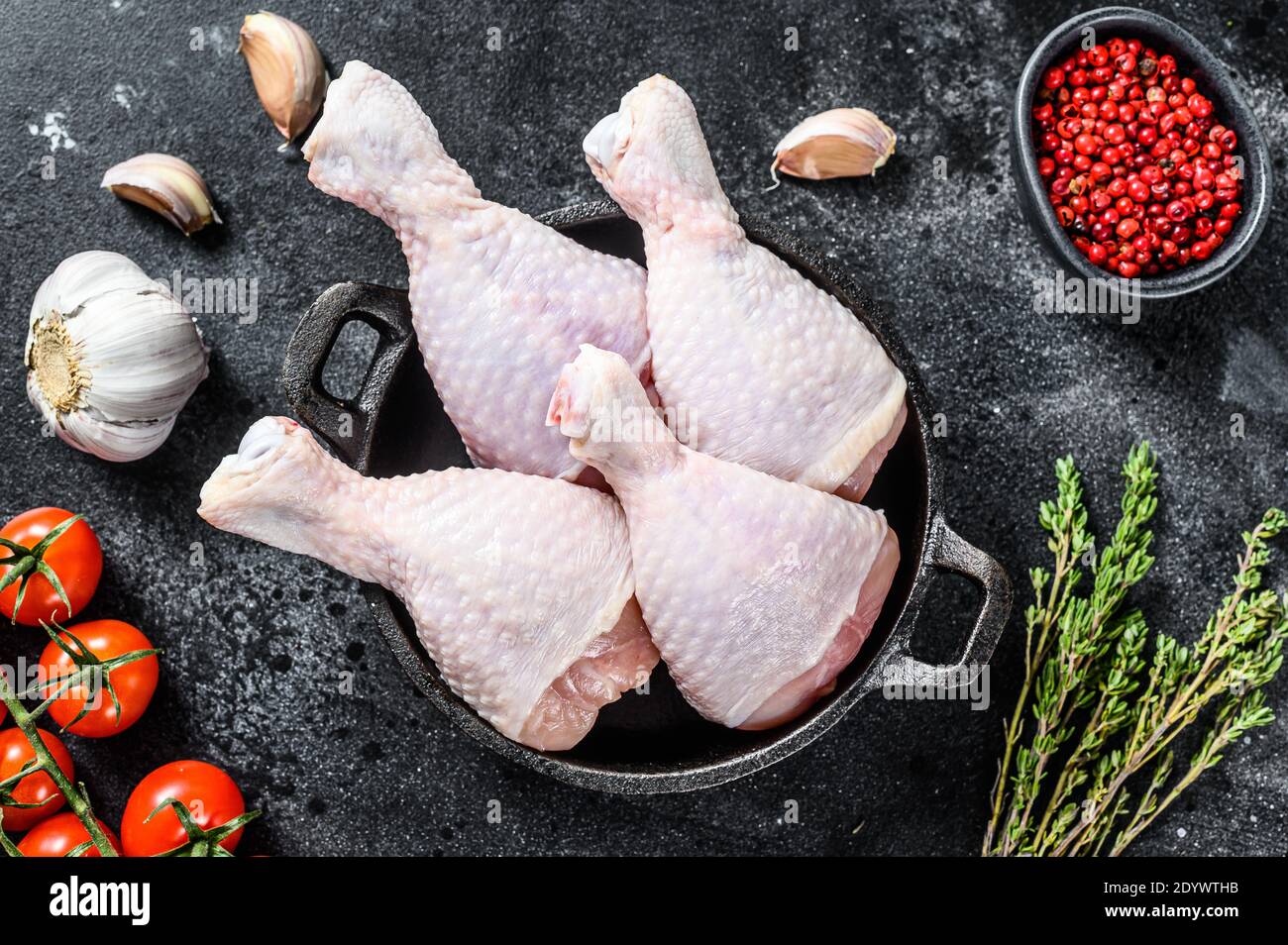 Pilons de poulet frais, jambes avec ingrédients pour la cuisson dans une  poêle. Viande de volaille biologique. Arrière-plan noir. Vue de dessus  Photo Stock - Alamy