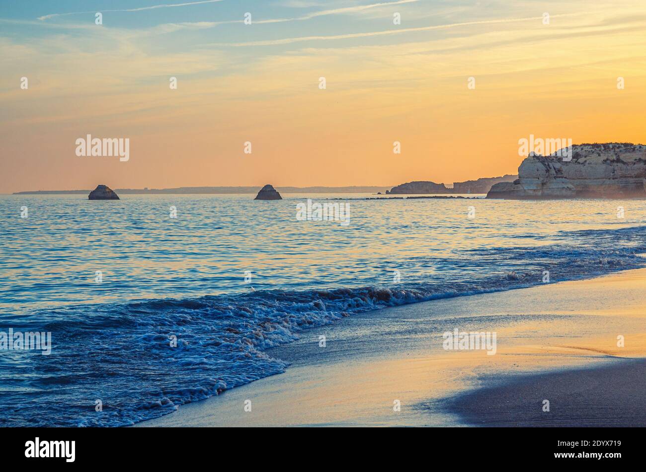 Paysage de la belle plage de sable Praia da Rocha avec des rochers et des falaises dans la ville de Portimao du quartier de l'Algarve, coucher de soleil doré sur les vagues de l'Oce Atlantique Banque D'Images